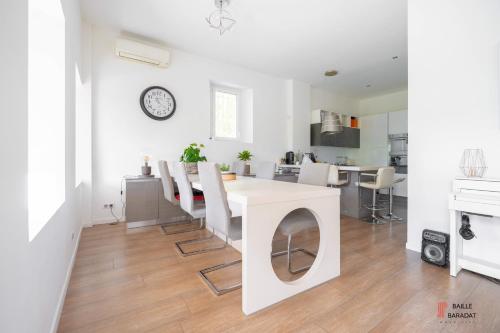 a kitchen and dining room with a white table and chairs at Villa QUEEN Marseille avec jardin, piscine et spa chauffé interieur - 15 couchages in Marseille