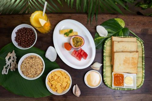 a table with plates of food and bowls of different foods at Eden Beach Resort By EHM in Koh Rong Sanloem