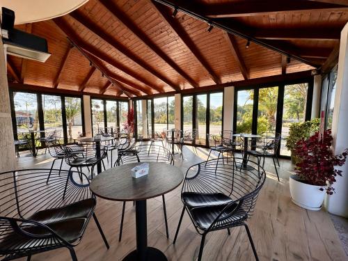 a restaurant with tables and chairs and windows at Room rental in Velipojë