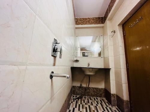 ein Bad mit WC und ein Telefon an der Wand in der Unterkunft Hotel Mani International in Patna