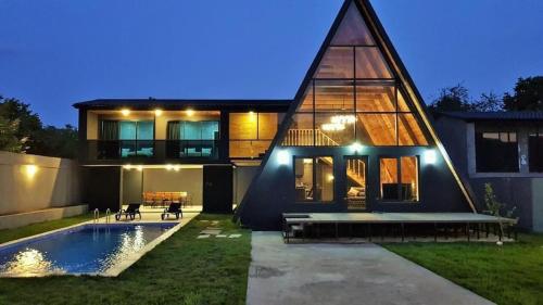a house with a swimming pool in front of it at Qafqaz Wood Chalet in Gabala