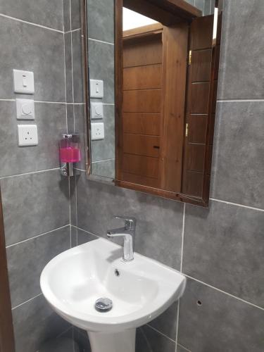 a bathroom with a white sink and a mirror at مورايا Murraya in Abyār ‘Alī