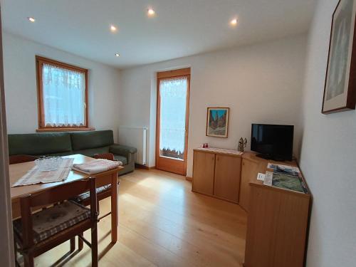 a living room with a green couch and a television at Appartamento a Madonna di Campiglio in Madonna di Campiglio