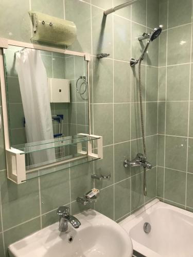 y baño con lavabo y ducha con espejo. en Amiryan apartment, en Ereván