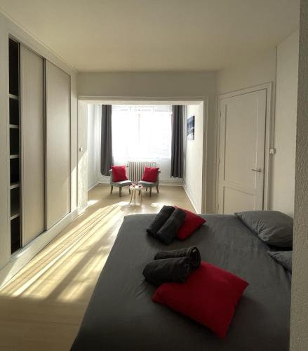 - une chambre avec un lit doté d'oreillers rouges dans l'établissement Escapade face à la mer, à Malo-les-Bains