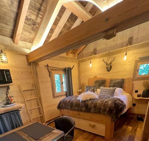 um quarto com uma cama num chalé de madeira em Les Écrins du Val de Mouthe, JURA 