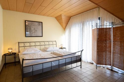 a bedroom with a bed and a large window at Großzügiges Feriendomizil im Herzen von Sankt Aldegund in Sankt Aldegund