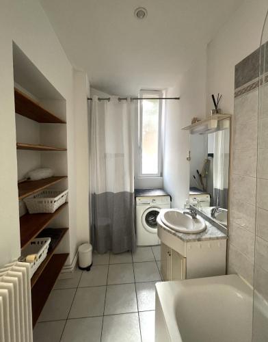 une salle de bain avec un lavabo et une machine à laver dans l'établissement Escapade face à la mer, à Malo-les-Bains