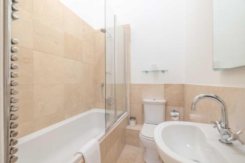 a bathroom with a tub and a sink and a toilet at Windsor Gem: 1-Bed Oasis Near Castle in Windsor