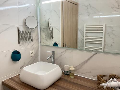 a bathroom with a white sink and a mirror at La Prom 2 - a two bedroom apartment with a sea view in Nice