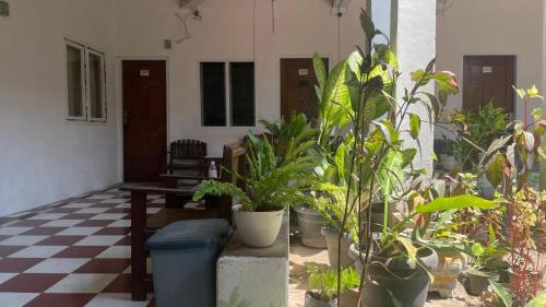 a room with potted plants on a checkered floor at Hotel Rejeki in Lewoleba