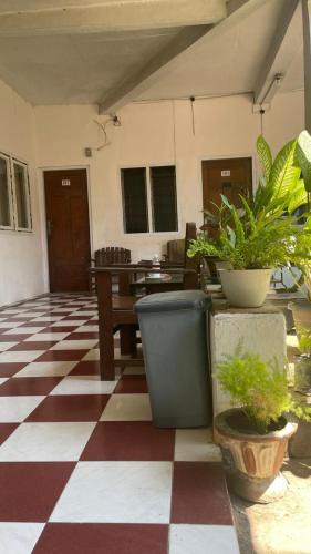 een kamer met een geruite vloer en potplanten bij Hotel Rejeki in Lewoleba