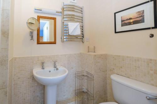 ein Badezimmer mit einem Waschbecken, einem WC und einem Spiegel in der Unterkunft 2 Ogilvie Lodge in Thorpeness