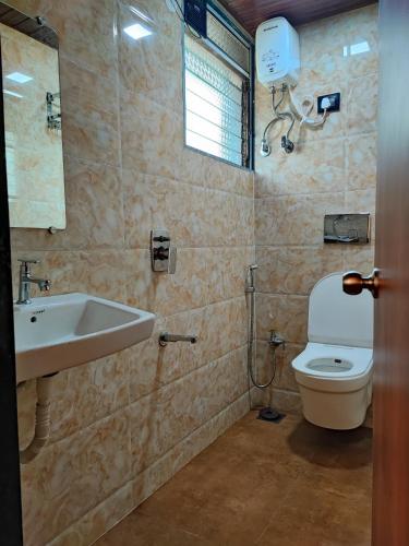 a bathroom with a sink and a toilet at Hotel Starlit in Navi Mumbai