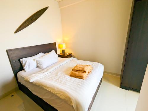 een slaapkamer met een bed met een bruine tas erop bij Lovina 27-AB at One Residence(near Ferry & Megamall) in Batam Center