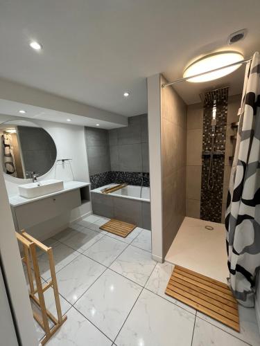 une salle de bain avec une baignoire, un lavabo et une douche dans l'établissement La Botte, à Épinal