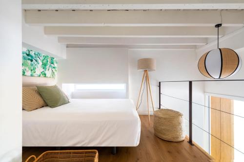 1 dormitorio con cama blanca y espejo en MonKeys Apartments Luxury Puerta de la Maestranza en Sevilla