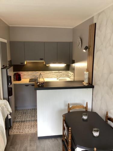 une cuisine avec une table noire et un comptoir dans l'établissement Appartement cocooning, à Villard-de-Lans