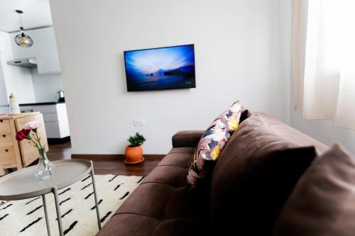 uma sala de estar com um sofá castanho e uma mesa em Cozy condo near to the beach em Dar Bouazza