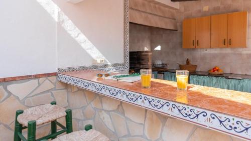 una cocina con 2 vasos de zumo de naranja en una barra en Villa Cañadu Nerja by Ruralidays, en Nerja
