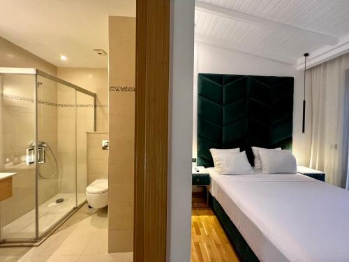 ein Schlafzimmer mit einem großen Bett und einer Dusche in der Unterkunft Golf view Villa with Jacuzzi- By AppartAli in Bouskoura