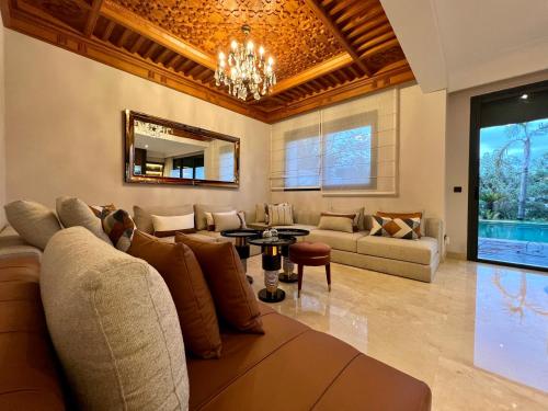 a living room with a couch and a table at Golf view Villa with Jacuzzi- By AppartAli in Bouskoura