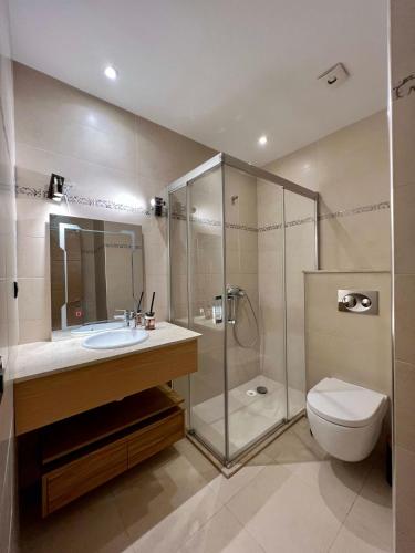 a bathroom with a shower and a sink and a toilet at Golf view Villa with Jacuzzi- By AppartAli in Bouskoura