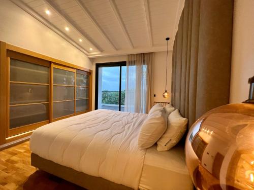 a bedroom with a large bed and a large window at Golf view Villa with Jacuzzi- By AppartAli in Bouskoura