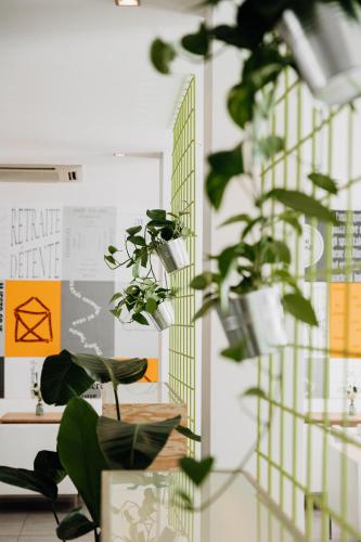 a room with green plants and a wall with posters at The Pure, Frankfurt, a Member of Design Hotels in Frankfurt/Main