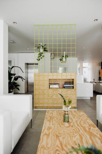 a living room with a table and a kitchen at The Pure, Frankfurt, a Member of Design Hotels in Frankfurt/Main