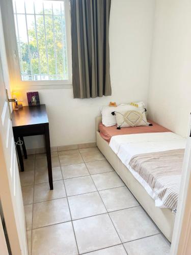 une petite chambre avec un lit et un bureau dans l'établissement Appartement 312 supérieur - LES SUITES DE ROBINSON - Résidence avec piscine en bord de Siagne, à Mandelieu-La-Napoule, à Mandelieu-la-Napoule