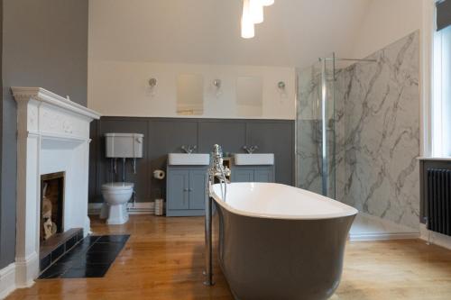 a large bathroom with a tub and a fireplace at The Finch Hatton Arms in Sleaford