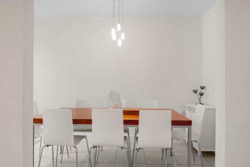 a dining room with a table and white chairs at Molesey Apartments in East Molesey