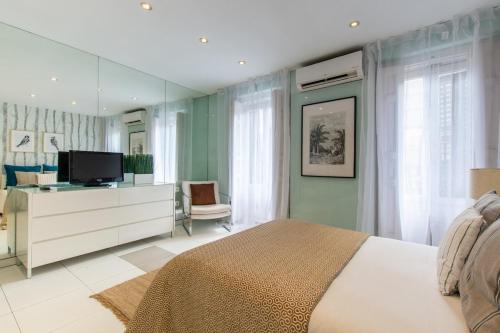 1 dormitorio con 1 cama y TV en AP Edificio Gran Via, en Madrid