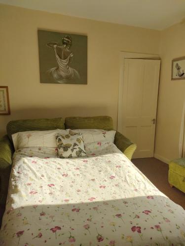 a bedroom with a bed with a flowered comforter at Forth Road Bridge Views in Queensferry