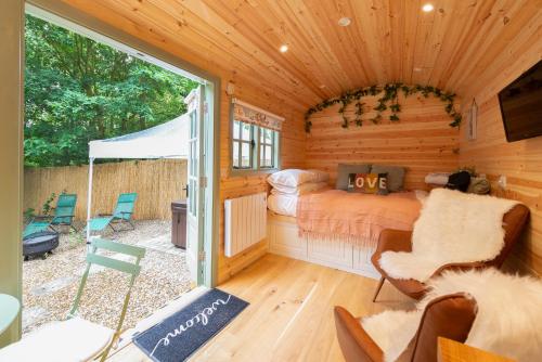 a room with a bed in a log cabin at Shepherds Hut with Hot Tub 