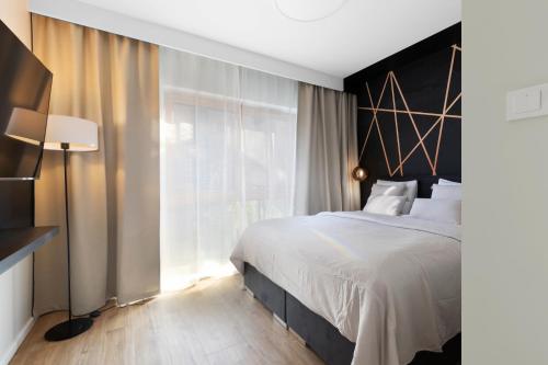 1 dormitorio con cama grande y ventana grande en Elite Apartments Nadmotławie Superior, en Gdansk