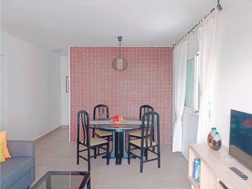 a dining room with a table and chairs and a brick wall at Live La Laguna Gracia in Las Lagunas