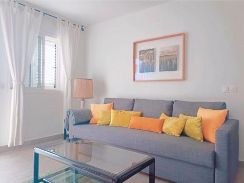 a living room with a blue couch with colorful pillows at Live La Laguna Gracia in Las Lagunas