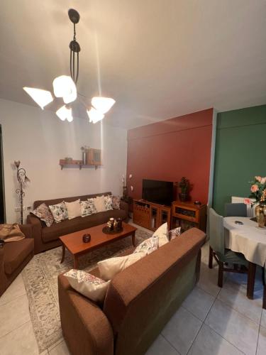 a living room with a couch and a tv at Cozy place in Kozani