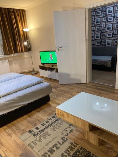 a bedroom with a bed and a tv and a table at Center Piac Aparman in Debrecen