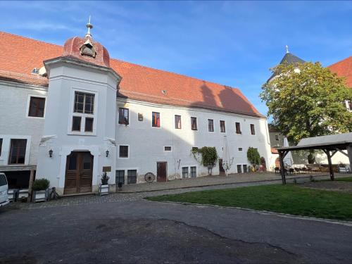 duży biały budynek z czerwonym dachem w obiekcie Schloss Hotel Wurzen w mieście Wurzen