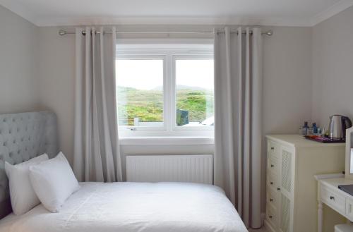 a bedroom with a bed and a window at Grimisdale Guest House in Leverburgh