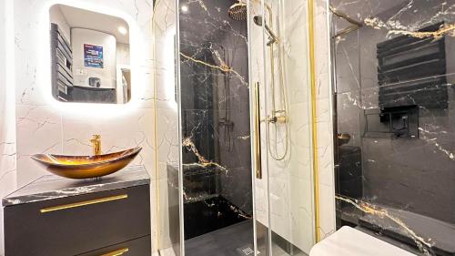 W łazience znajduje się drewniana umywalka i prysznic. w obiekcie Apartament Złoty w Opolu w mieście Opole