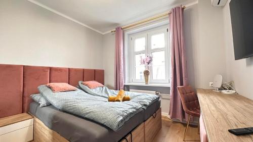 um quarto com uma cama com um urso de peluche em Apartament Złoty w Opolu em Opole