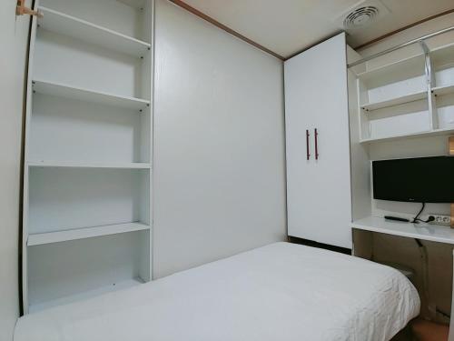 um quarto com uma cama branca e uma secretária em Full house em Seul