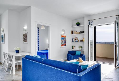 sala de estar con sofá azul y mesa en Le Capannelle, en SantʼAgata sui Due Golfi
