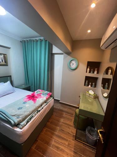 een slaapkamer met een bed en een klok aan de muur bij luxury flat with garden and private entrance شقة فاخرة بحديقة و مدخل خاص in Caïro