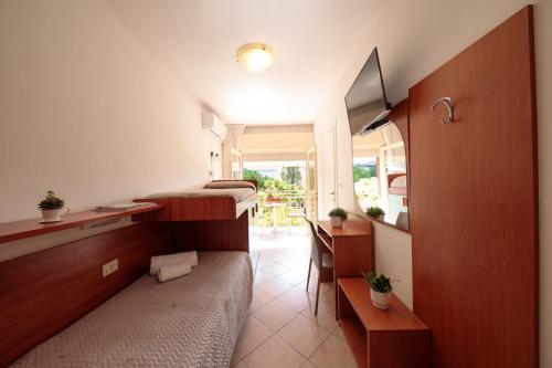 Habitación pequeña con cama, escritorio y escritorio. en Hotel Madison en Lido di Jesolo