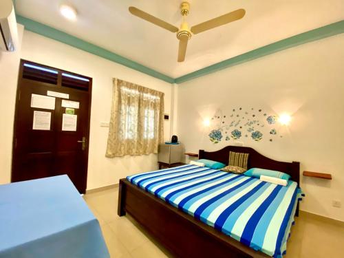 a bedroom with a bed and a ceiling fan at Tamara Motels in Hikkaduwa